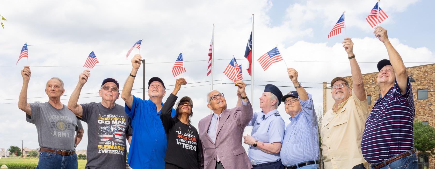 People standing outside holding up American flags