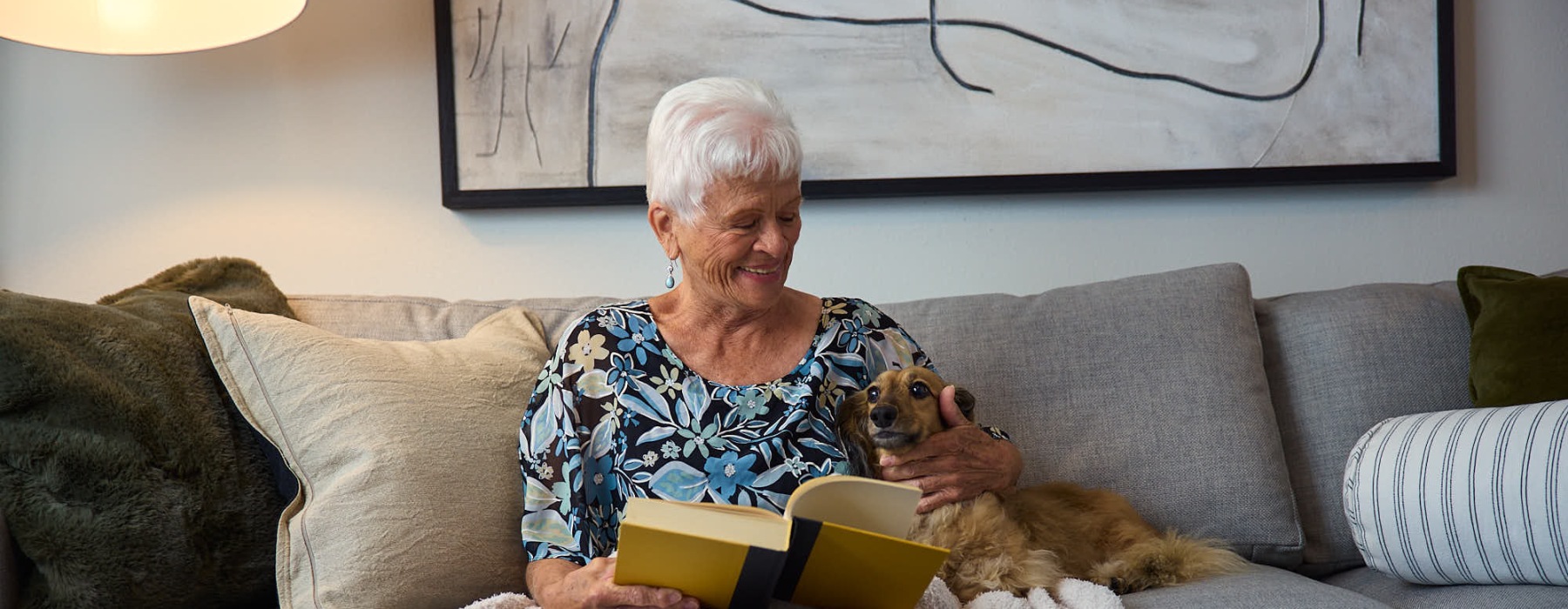 a woman reading a book with a dog