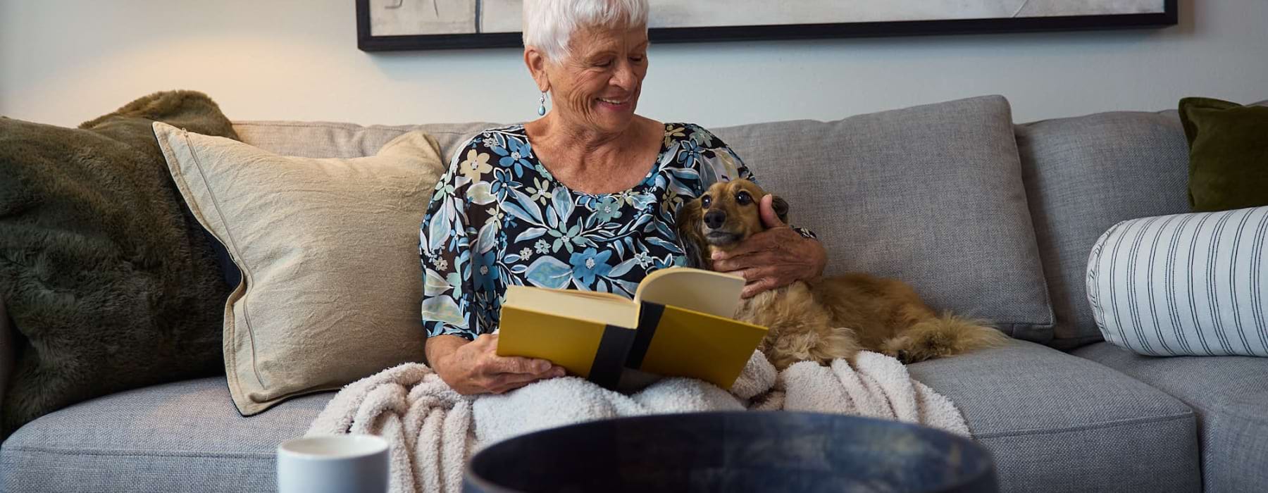 a woman reading a book with a dog