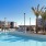 a swimming pool with palm trees and buildings in the background