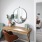 a room with a round mirror and a table with chairs